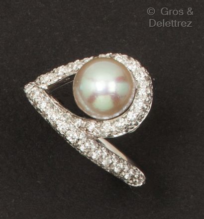 A white gold ring set with a cultured pearl...