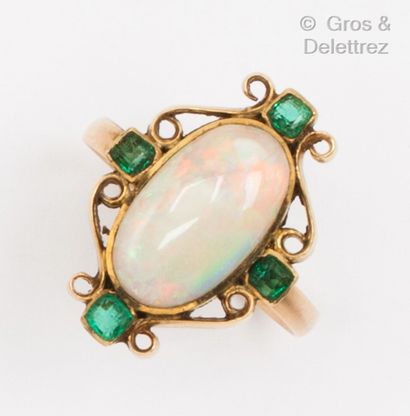 null Yellow gold ring set with an opal and four emeralds in a scroll setting. Finger...