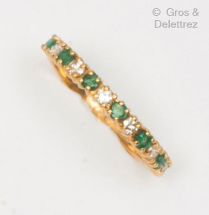 null Yellow gold half wedding ring set with faceted emeralds and brilliant-cut diamonds....