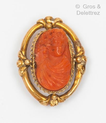 null Yellow gold brooch with palmettes, holding a cameo on coral representing the...
