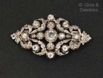 null Broche en or gris et argent ajouré à décor de rinceaux et feuillages, ornée...