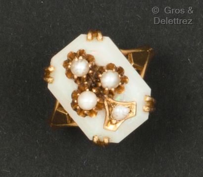 null Yellow gold ring set with an octagonal opal and a pearl-set fleur-de-lis motif....