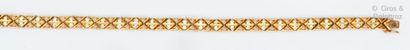 Bracelet articulé en or jaune ajouré de croisillons...