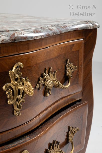 null A curved chest of drawers in plum veneer and native woods inlaid with leaves,...