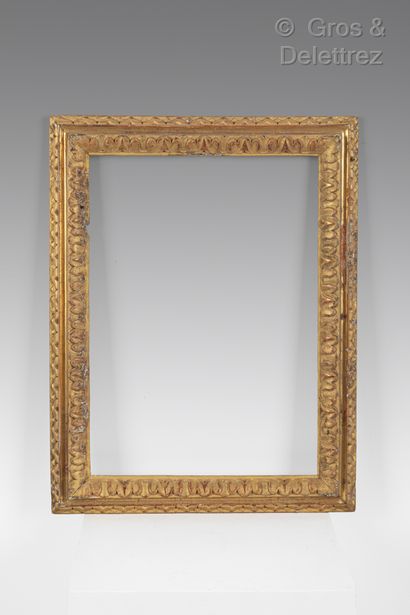 A carved and gilded wood frame with a frieze...