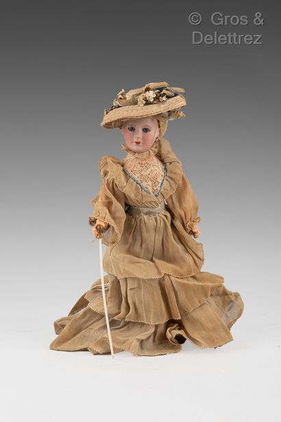 null Porcelain head doll wearing a crepe and lace dress and holding a cane. She wears...