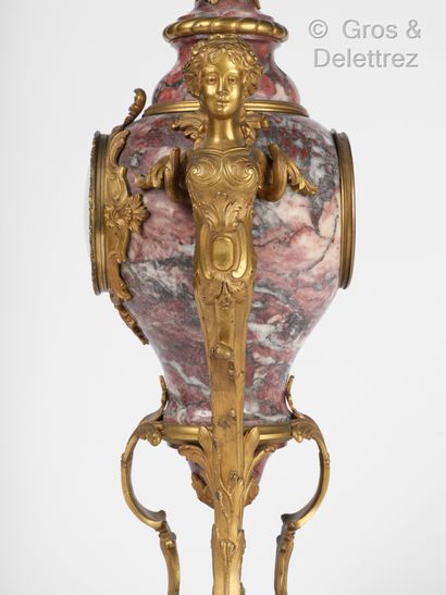 null Urn-shaped clock in red veined marble, the ornaments in chased and gilded bronze...