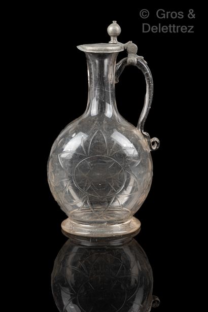 null Glass pitcher with flattened body with engraved decoration of a stylized sun....
