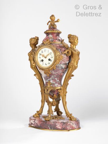 null Urn-shaped clock in red veined marble, the ornaments in chased and gilded bronze...