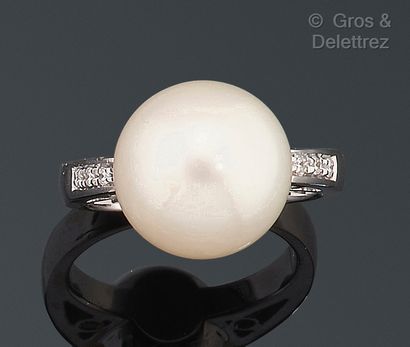 null Bague en or gris, ornée d’une perle de culture épaulée de diamants taillés en...