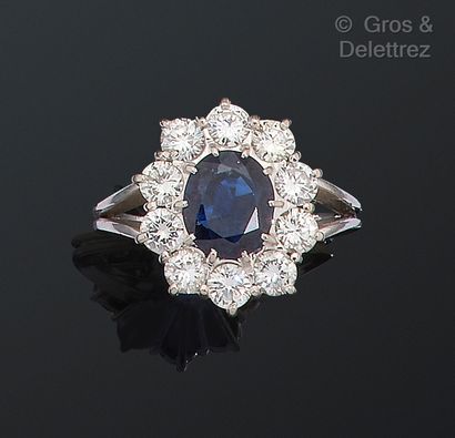 null White gold "Flower" ring, set with an oval sapphire in a circle of brilliant-cut...