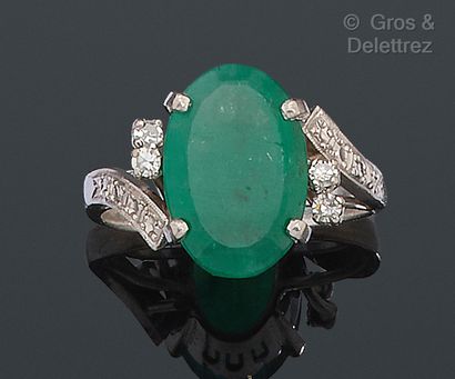 null White gold ring, set with an oval emerald and 8/8 diamonds. The ring forms a...