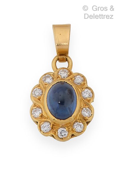 null Yellow gold pendant, decorated with a cabochon sapphire surrounded by diamonds....