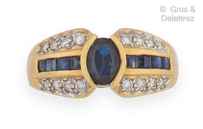 null Yellow gold ring, set with a sapphire, a line of calibrated sapphires and a...