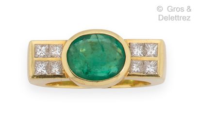 null Yellow gold ring set with an oval emerald and princess diamonds. Finger size...