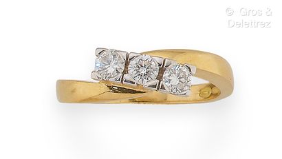 null Yellow gold "Crossed" ring, held by three brilliant-cut diamonds. Finger size...