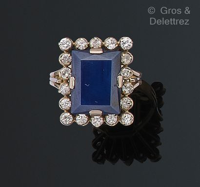 null White gold ring set with a rectangular sapphire in a circle of brilliant-cut...