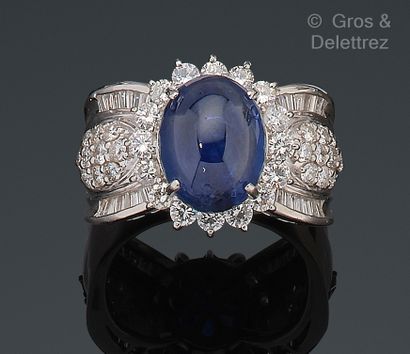 null Platinum ring, set with a cabochon sapphire surrounded by lines of brilliant-cut...