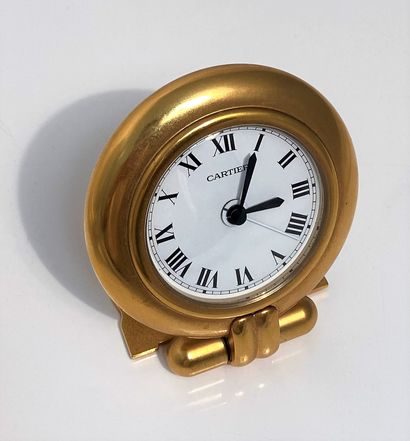CARTIER Travel alarm clock in gilt metal, round case (7.8 cm), white dial with painted...