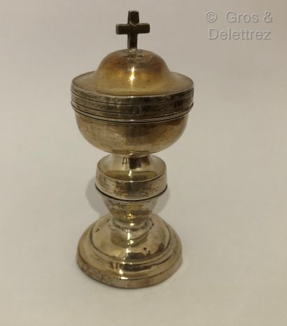 null Pixyde in silver resting on a footouche with doucine surmounted by a cross....