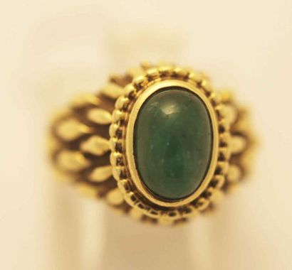 null Bague en or jaune ciselé ornée d'une émeraude cabochon. P. 6,7 g.