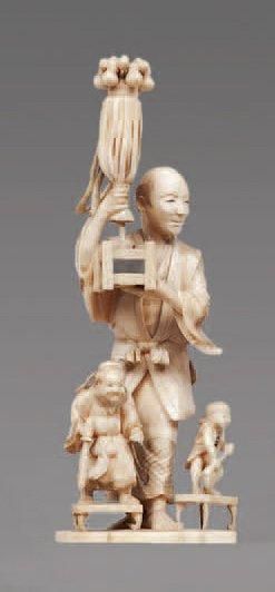 null OKIMONO en ivoire sculpté représentant un homme debout, présentant sur une base...