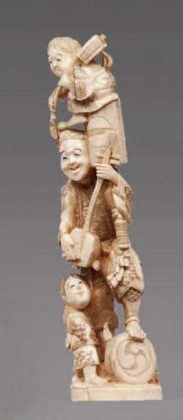null OKIMONO en ivoire marin figurant un musicien et deux enfants, l'un sur épaule....