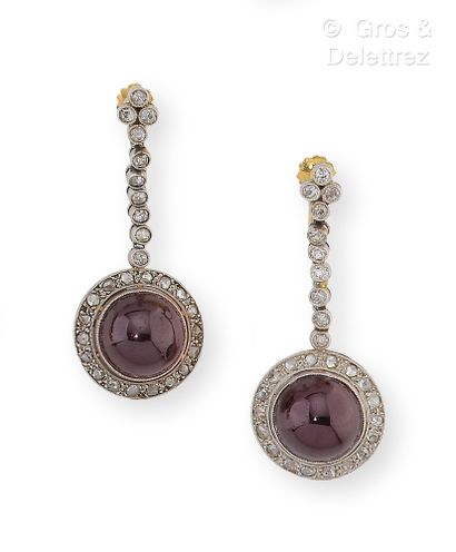 null Pair of earrings in white and yellow gold, adorned with garnet cabochons surrounded...