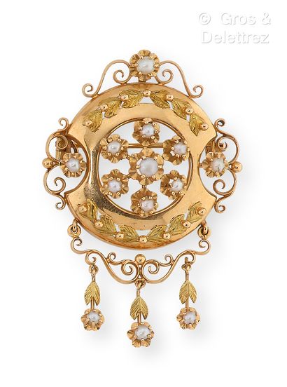 null Circular brooch in yellow gold, surmounted by friezes of scrolls and leaves....
