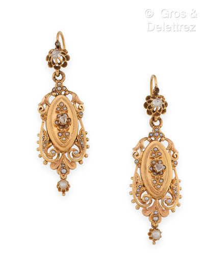 null Pair of yellow gold earrings with carved and pierced scrolls underlined by fine...