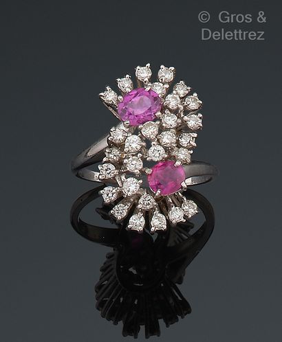 null White gold ring, set with two faceted rubies surrounded by brilliant-cut diamonds....