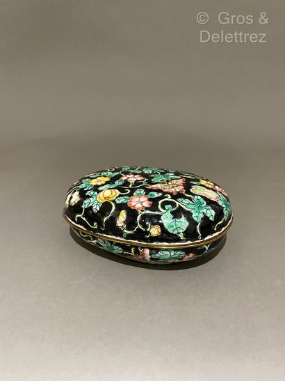 null China. Oval box in full enamel decorated with flowers and cucurbits on black...