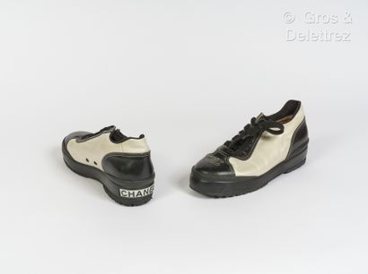 CHANEL Pair of laced up sneakers in black lambskin leather, pearly, soles slightly...