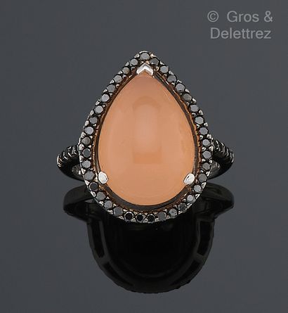 null White gold ring set with a pear-shaped rose quartz cabochon surrounded and shouldered...