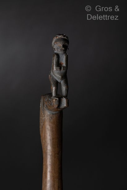 null Cane in light wood, the knob showing a standing figure, the main part partially...