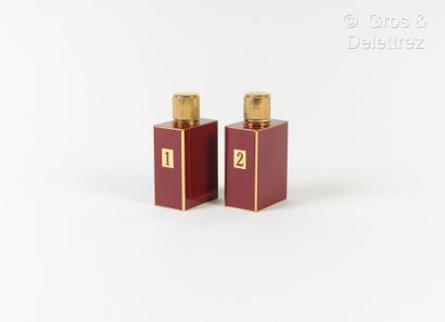 null HERMES Paris - Set of two bottles in gilt metal with burgundy enamel.