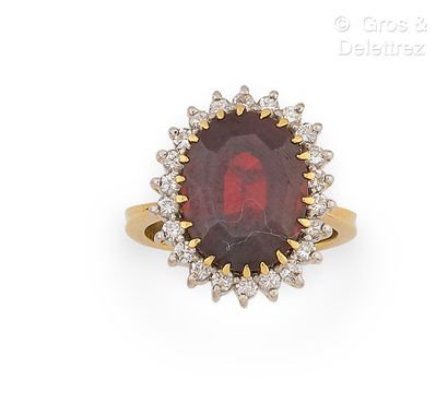 null Yellow gold and platinum ring, set with a faceted garnet in a circle of brilliant-cut...