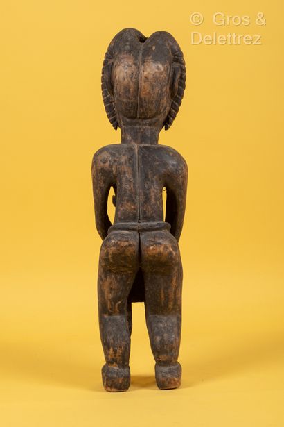 TCHAD Sculpture féminine en bois sculpté patinée, représentée debout, une main sur...