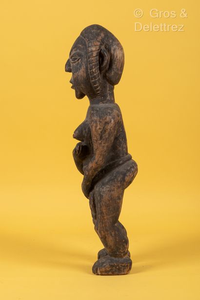 TCHAD Sculpture féminine en bois sculpté patinée, représentée debout, une main sur...