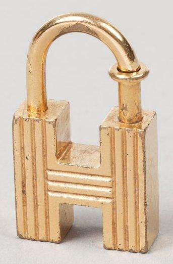 HERMÈS Paris made in France Porte-clefs en métal doré figurant un "H" godronné titré...
