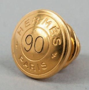 HERMÈS Paris Pin's en métal doré figurant un clou de selle daté 90.(*)