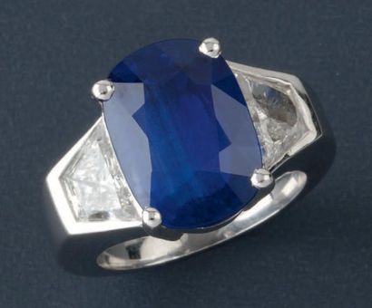 null Bague en or gris ornée d'un saphir coussin épaulé de deux diamants trapèze....