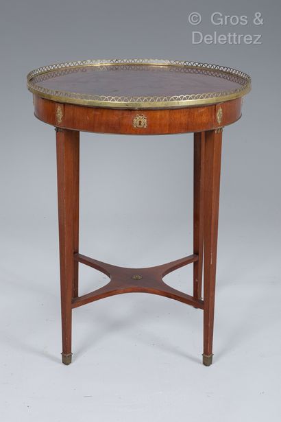 null Circular pedestal table in exotic wood veneer, one drawer in the waist. It rests...