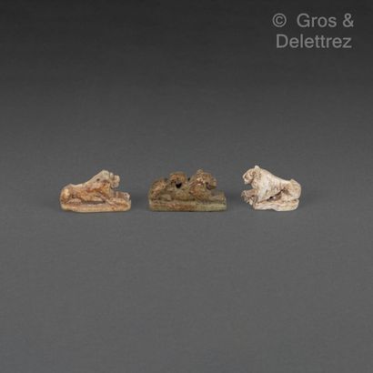 null Set of three amulets in the form of a reclining lion, one of which is inscribed...