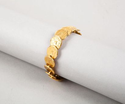 Yves Saint LAURENT Bracelet en métal doré composé d'un rang de piastres martelées,...