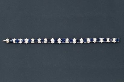 null Bracelet en or gris orné de 17 saphirs ovales alternés de motifs sertis chacun...