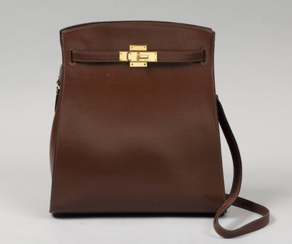 HERMÈS Paris made in France *Sac « Kelly sport « en cuir marron, attaches et fermoir...