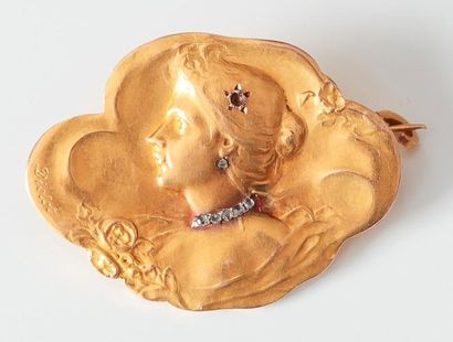 Broche en or jaune ciselé à décor d'une femme...