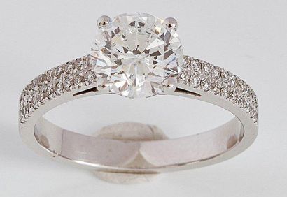 null Bague solitaire en or gris ornée d'un diamant taillé en brillant épaulé de deux...