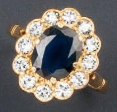 null Bague en or jaune ornée d'un saphir ovale dans un entourage de diamants taillés...